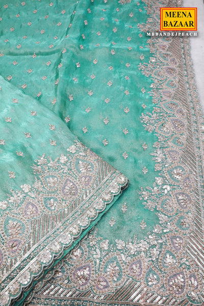 Turquoise fabric with silver embroidery, branded 'Meena Bazaar'.