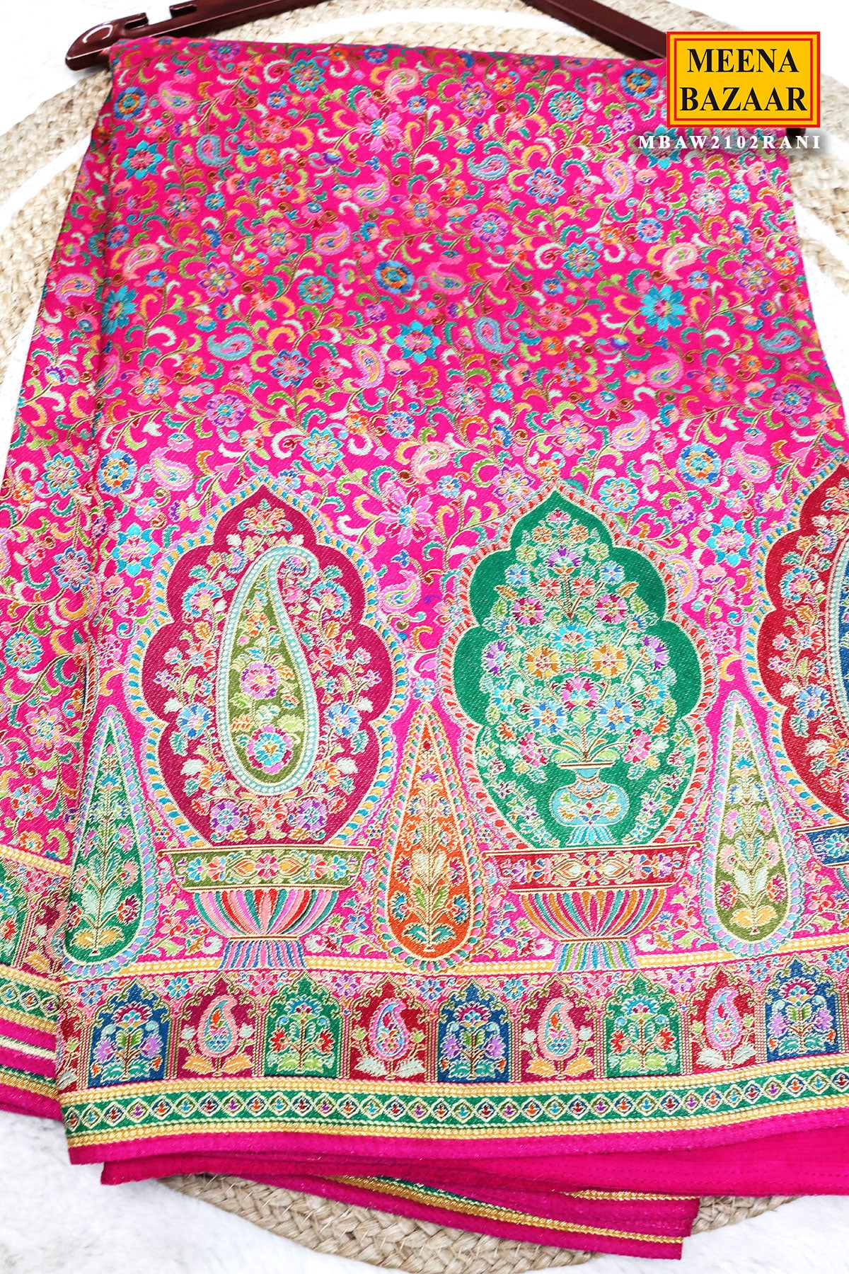 Colorful patterned fabric with intricate designs on a pink background, branded 'Meena Bazaar'.