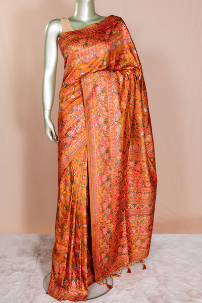 Orange saree with floral patterns on a mannequin against a beige background