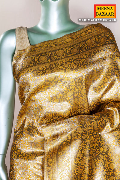 Saree with gold and brown pattern on a mannequin, branded 'Meena Bazaar'.